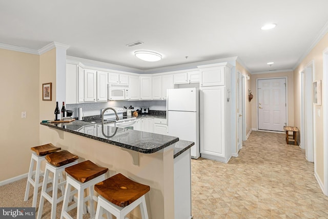 kitchen with visible vents, white appliances, crown molding, and a peninsula