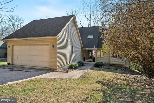 view of front of property with a front lawn, decorative driveway, a garage, and roof with shingles