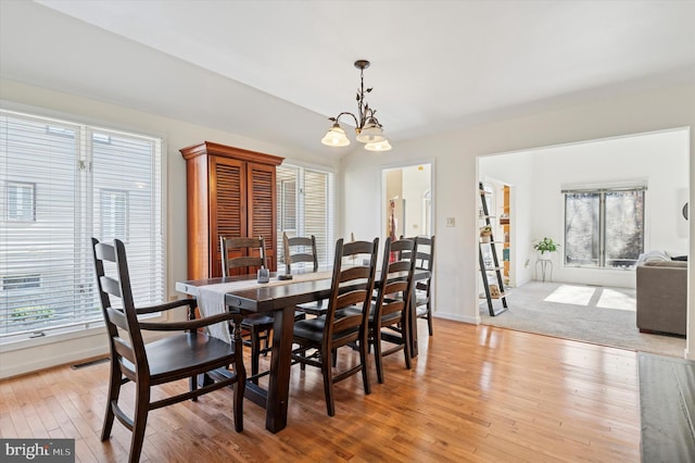 dining room featuring an inviting chandelier, light wood-style flooring, visible vents, and a wealth of natural light