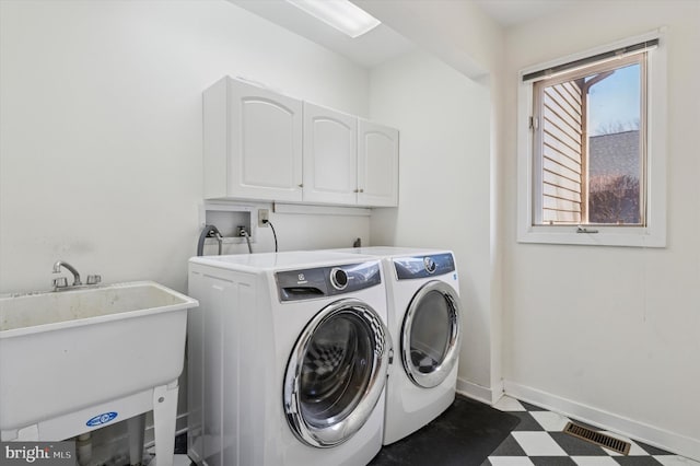 laundry room with visible vents, a sink, dark floors, cabinet space, and separate washer and dryer