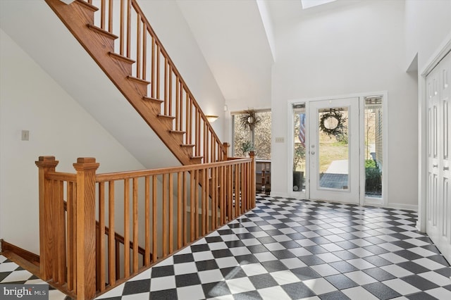 entrance foyer with tile patterned floors, stairs, a high ceiling, and baseboards