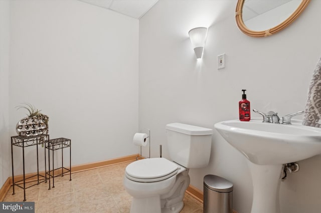 bathroom featuring baseboards and toilet