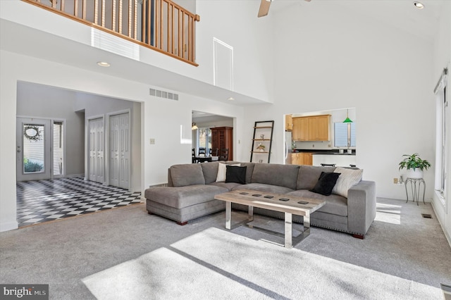 living area featuring visible vents, light carpet, recessed lighting, a high ceiling, and a ceiling fan