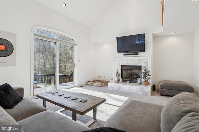 carpeted living area featuring recessed lighting, a fireplace, baseboards, and high vaulted ceiling