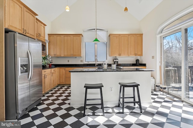 kitchen with tile patterned floors, high vaulted ceiling, stainless steel appliances, and dark countertops