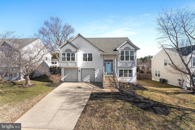 split foyer home with a front yard, central AC unit, fence, an attached garage, and concrete driveway