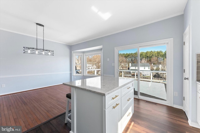 kitchen featuring light stone counters, dark wood-type flooring, white cabinets, and crown molding