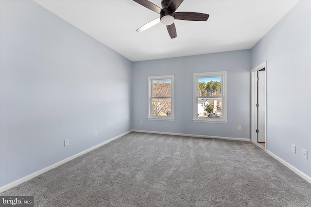 carpeted empty room with a ceiling fan and baseboards