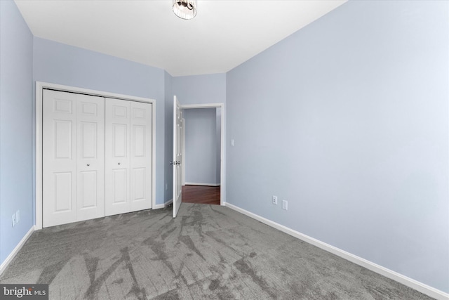 unfurnished bedroom featuring a closet, carpet flooring, and baseboards