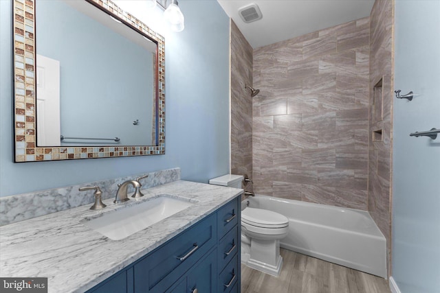 full bath with visible vents, toilet, shower / bathing tub combination, wood finished floors, and vanity