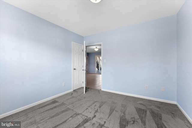 carpeted empty room with baseboards