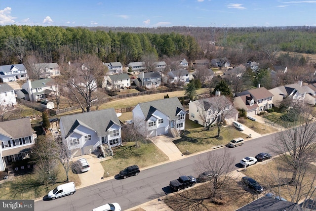 birds eye view of property featuring a wooded view and a residential view