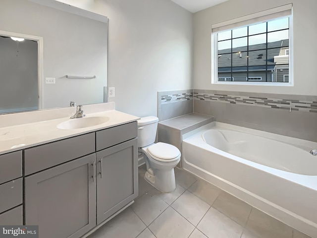 bathroom featuring tile patterned floors, a garden tub, vanity, and toilet