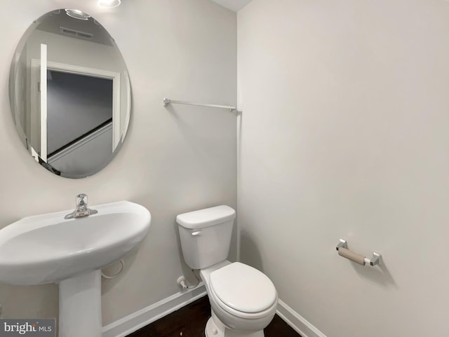 bathroom with toilet, baseboards, and a sink