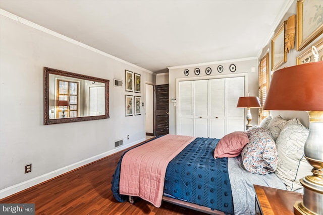 bedroom featuring a closet, visible vents, baseboards, and wood finished floors