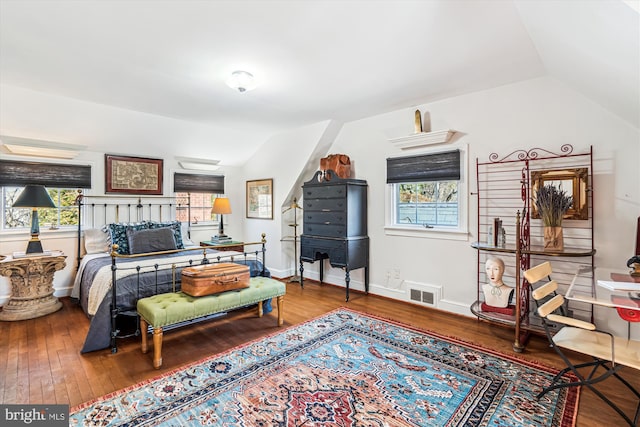 bedroom featuring vaulted ceiling, hardwood / wood-style flooring, multiple windows, and visible vents