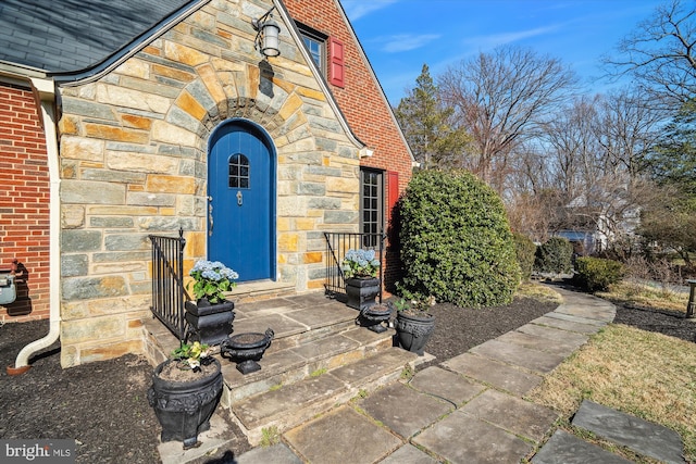 property entrance featuring brick siding and stone siding