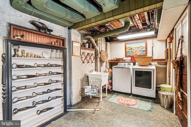 unfinished below grade area with a sink, washing machine and dryer, and brick wall