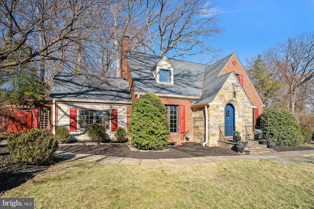 view of front of house with a front lawn, brick siding, stone siding, and a chimney