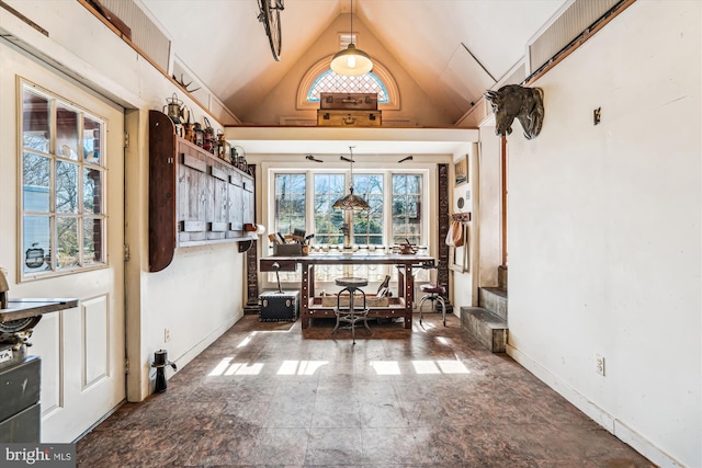 dining room featuring high vaulted ceiling and baseboards