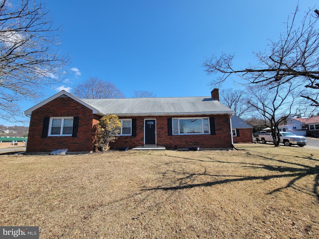 single story home with a front lawn, brick siding, and a chimney