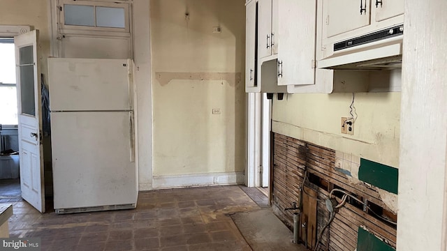 kitchen featuring under cabinet range hood and freestanding refrigerator