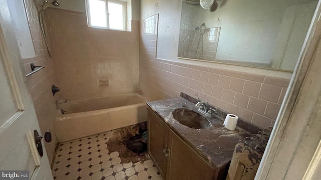 bathroom with vanity, tile walls, tub / shower combination, and backsplash