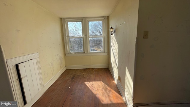 spare room featuring dark wood finished floors and baseboards