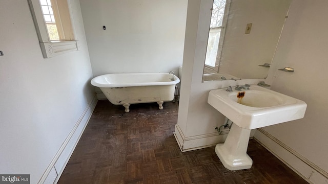 bathroom with baseboards and a freestanding bath