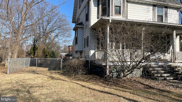 view of property exterior featuring a yard, fence, and covered porch