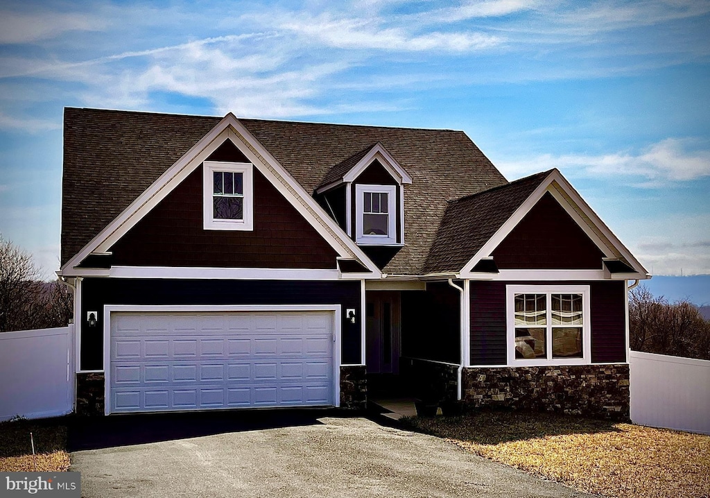 view of front of house with fence, a garage, and driveway