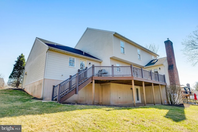 rear view of house featuring stairway, a lawn, and a wooden deck