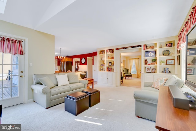 carpeted living room featuring an inviting chandelier