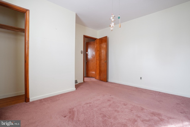 unfurnished bedroom with a closet, baseboards, and carpet flooring