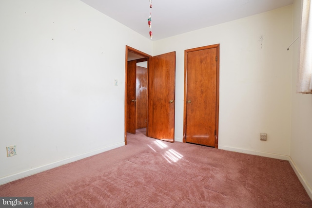 unfurnished bedroom with carpet flooring and baseboards