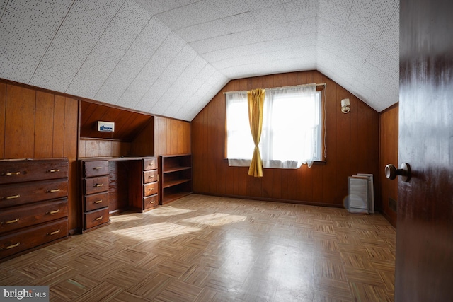 bonus room featuring wood walls and vaulted ceiling