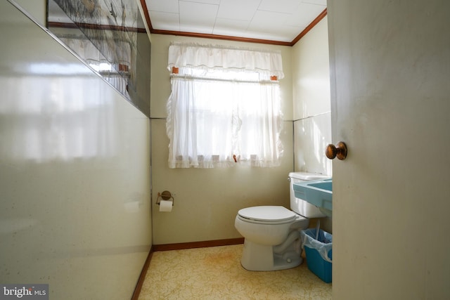 half bathroom featuring baseboards, toilet, and ornamental molding