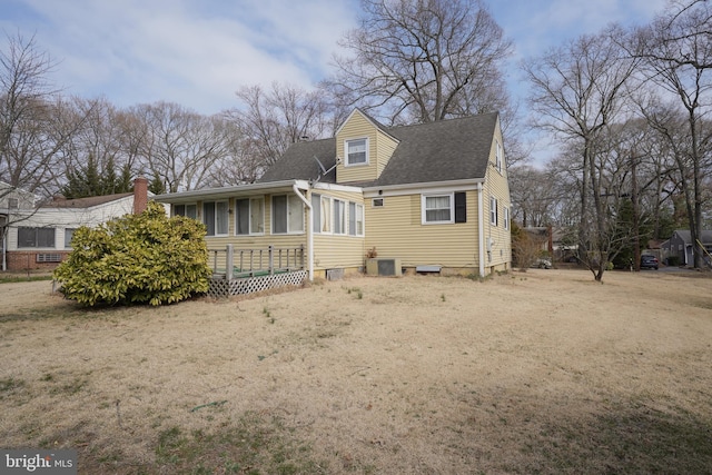 exterior space featuring a sunroom, driveway, and a shingled roof