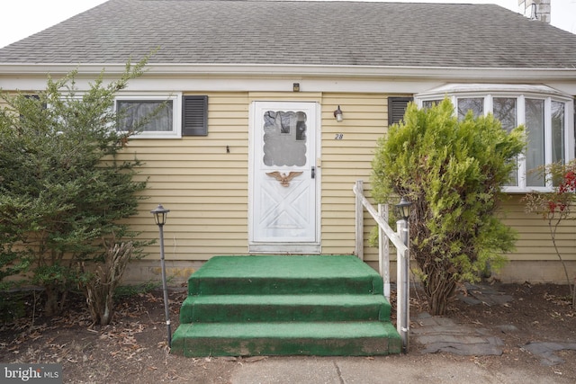 doorway to property featuring a shingled roof