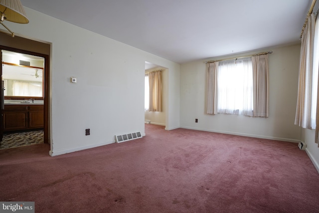 unfurnished room with visible vents, baseboards, and carpet floors