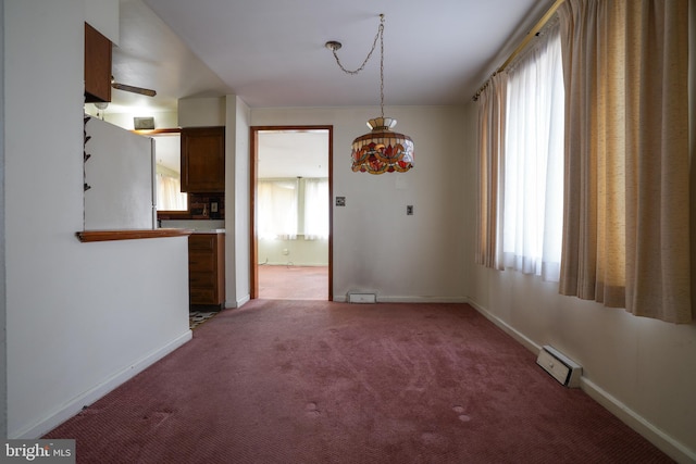 unfurnished dining area with baseboards and light carpet