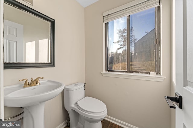 bathroom featuring toilet and baseboards