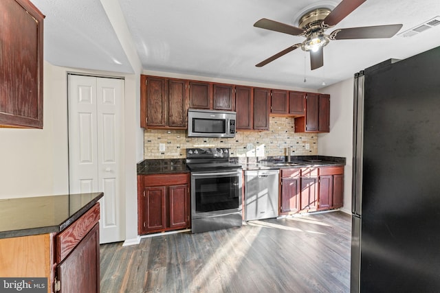 kitchen with backsplash, stainless steel appliances, dark wood-type flooring, and dark countertops