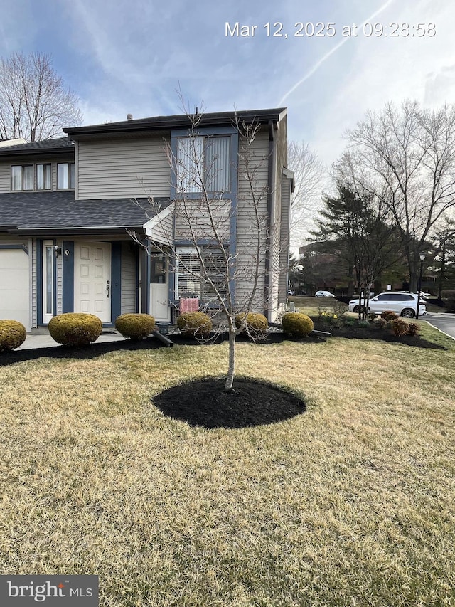 view of front of home featuring a front yard and a shingled roof