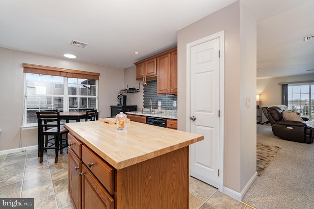 kitchen with visible vents, wooden counters, backsplash, and a center island