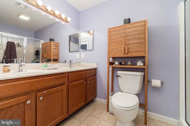 full bath featuring visible vents, double vanity, a sink, a shower stall, and toilet