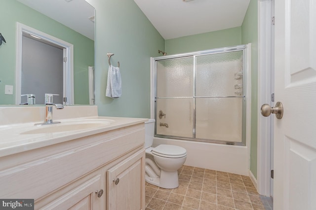 bathroom featuring enclosed tub / shower combo, toilet, and vanity