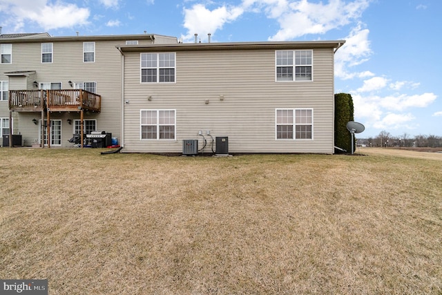 rear view of property featuring central air condition unit and a yard