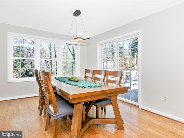 dining space with baseboards and light wood finished floors