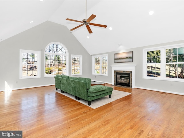 living area with a tiled fireplace, light wood-style flooring, and a wealth of natural light